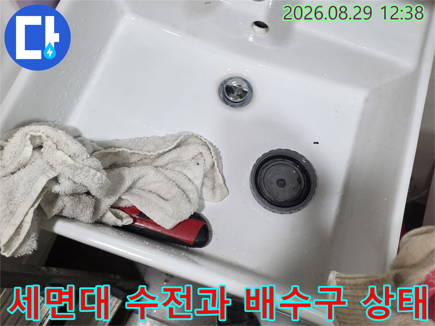 세면대 수전 부위와 배수구 팝업의 연결 상태를 촬영한 사진입니다.