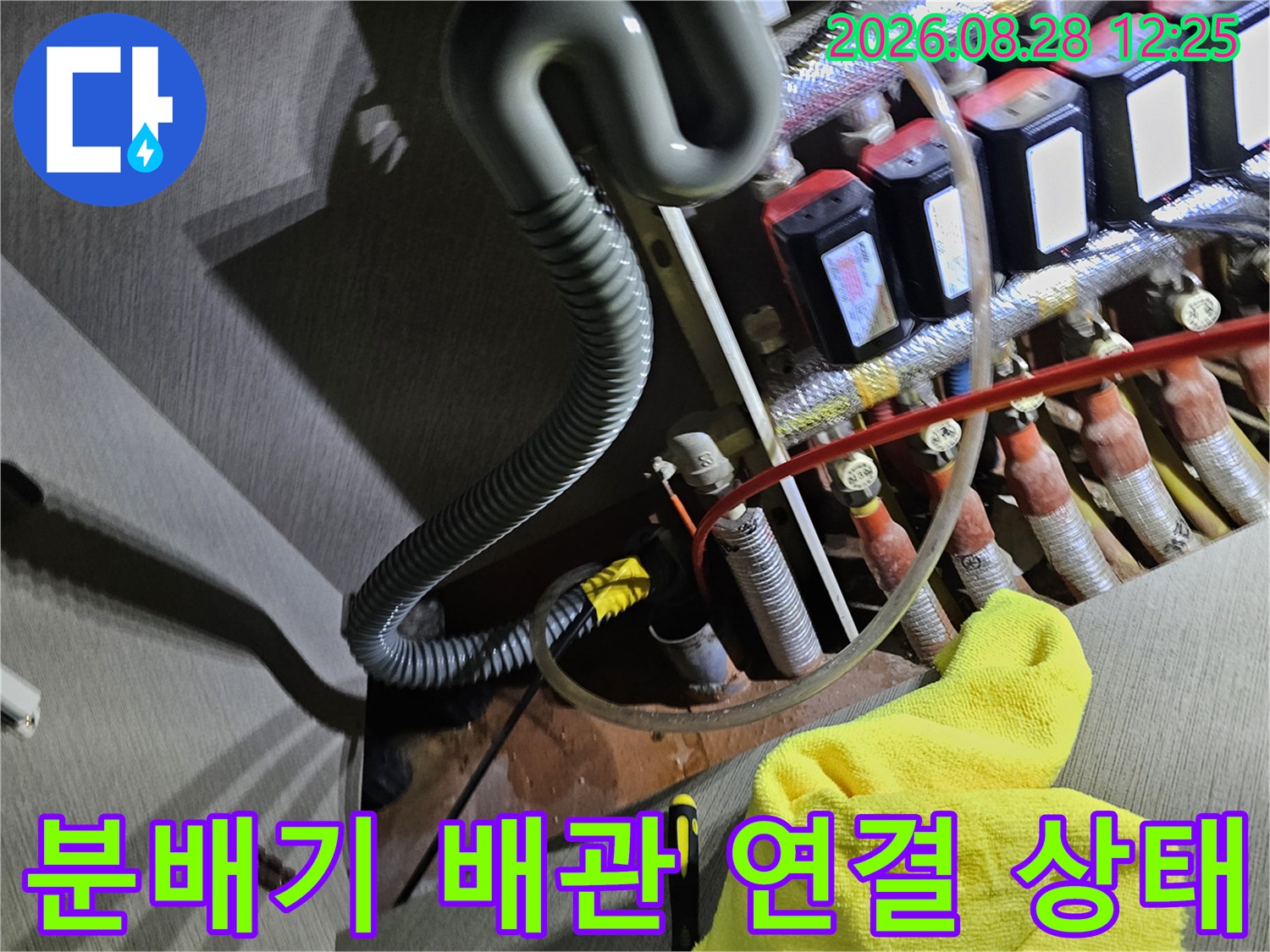 보일러 분배기의 밸브와 호스 연결 부위를 촬영한 현장 사진입니다.