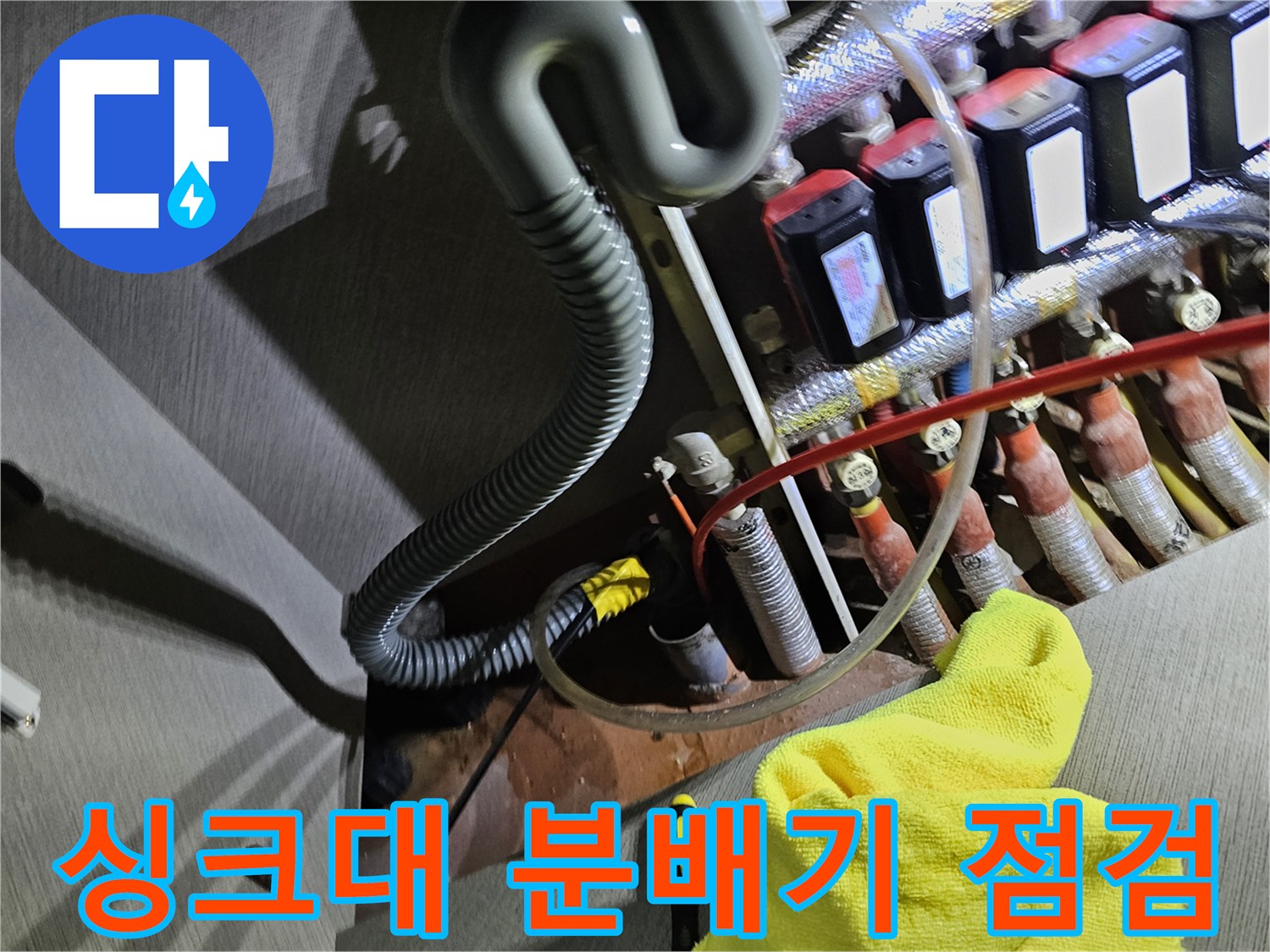 싱크대 하부장 분배기와 연결된 각종 배관의 상태를 점검하는 모습