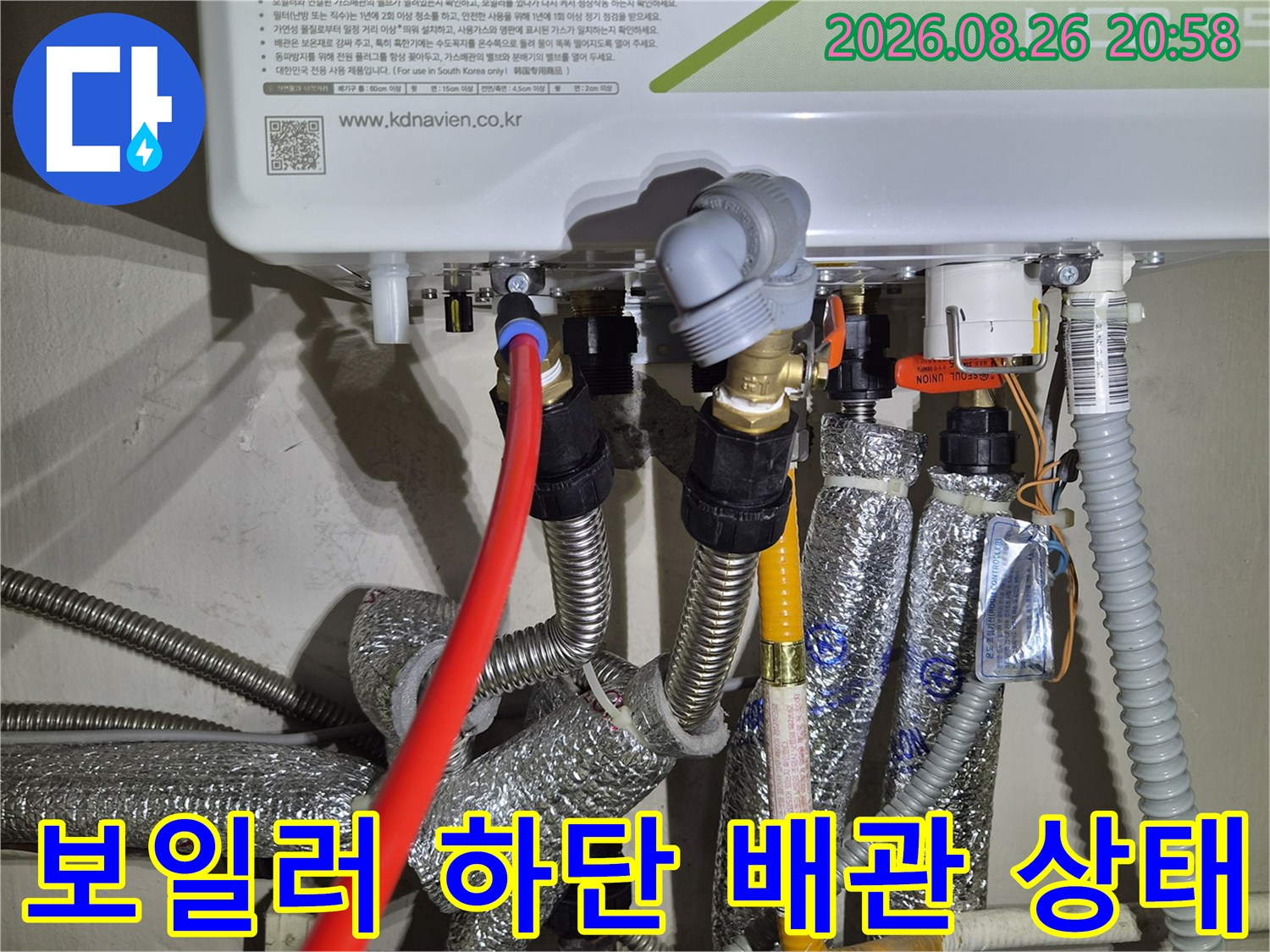 보일러 아래쪽의 여러 배관과 밸브들이 연결된 모습