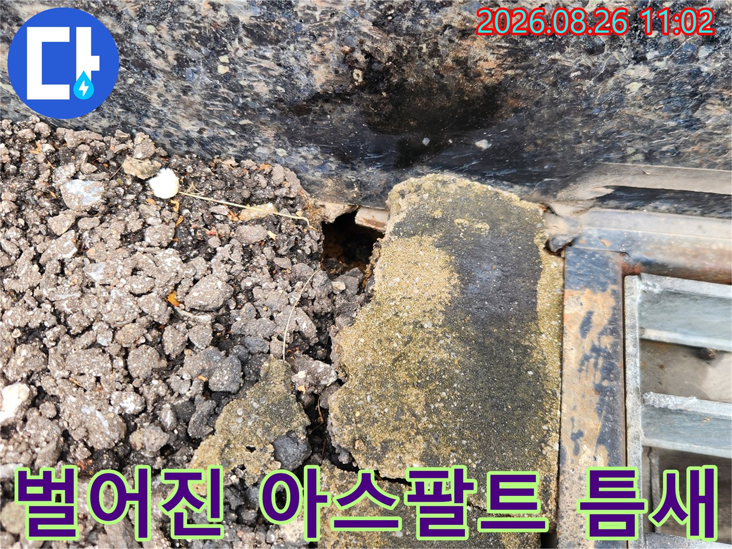아스팔트와 외벽 사이의 벌어진 틈과 파손된 지면