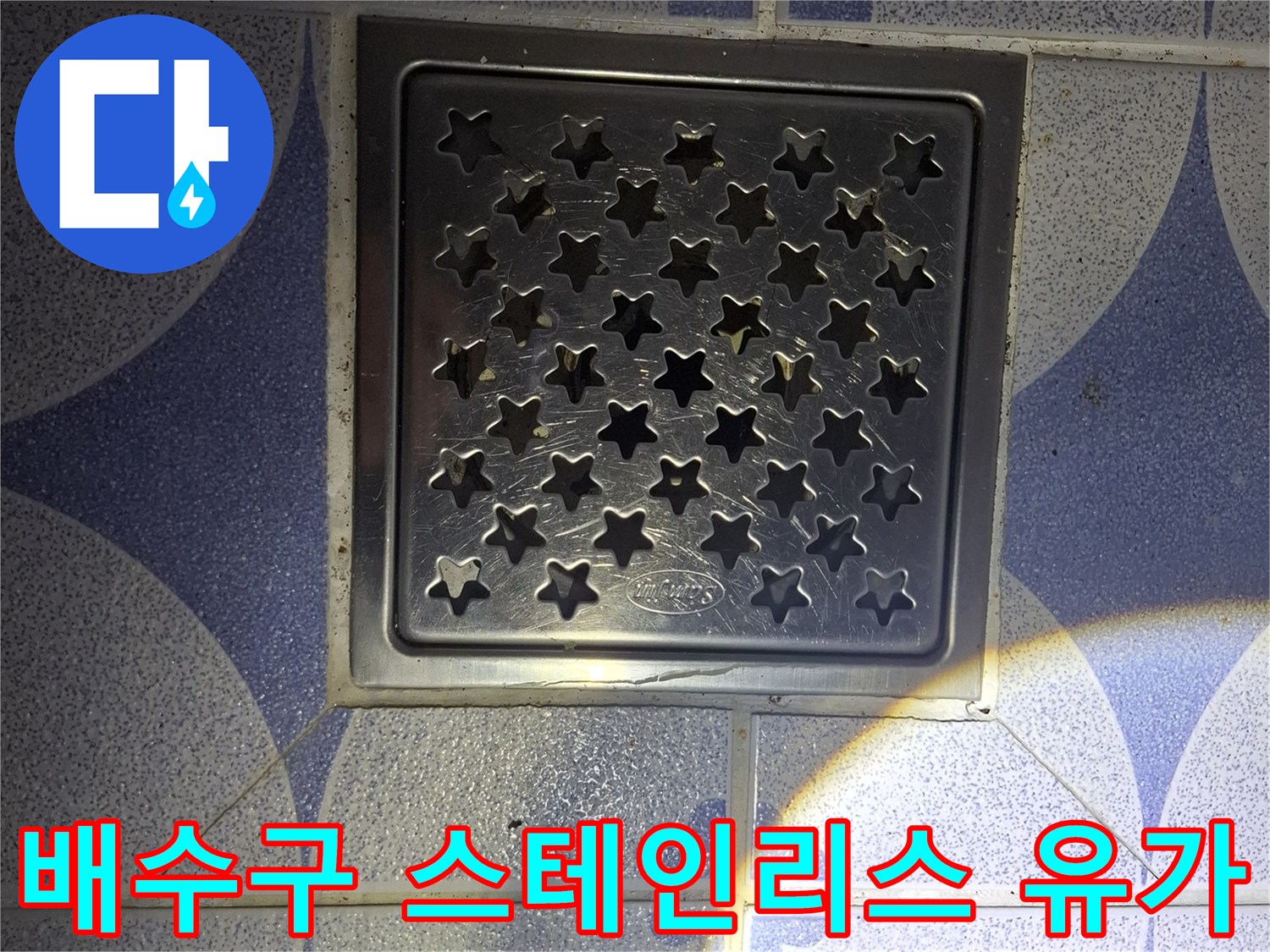 화장실 바닥에 설치된 사각형 모양의 스테인리스 배수구 유가