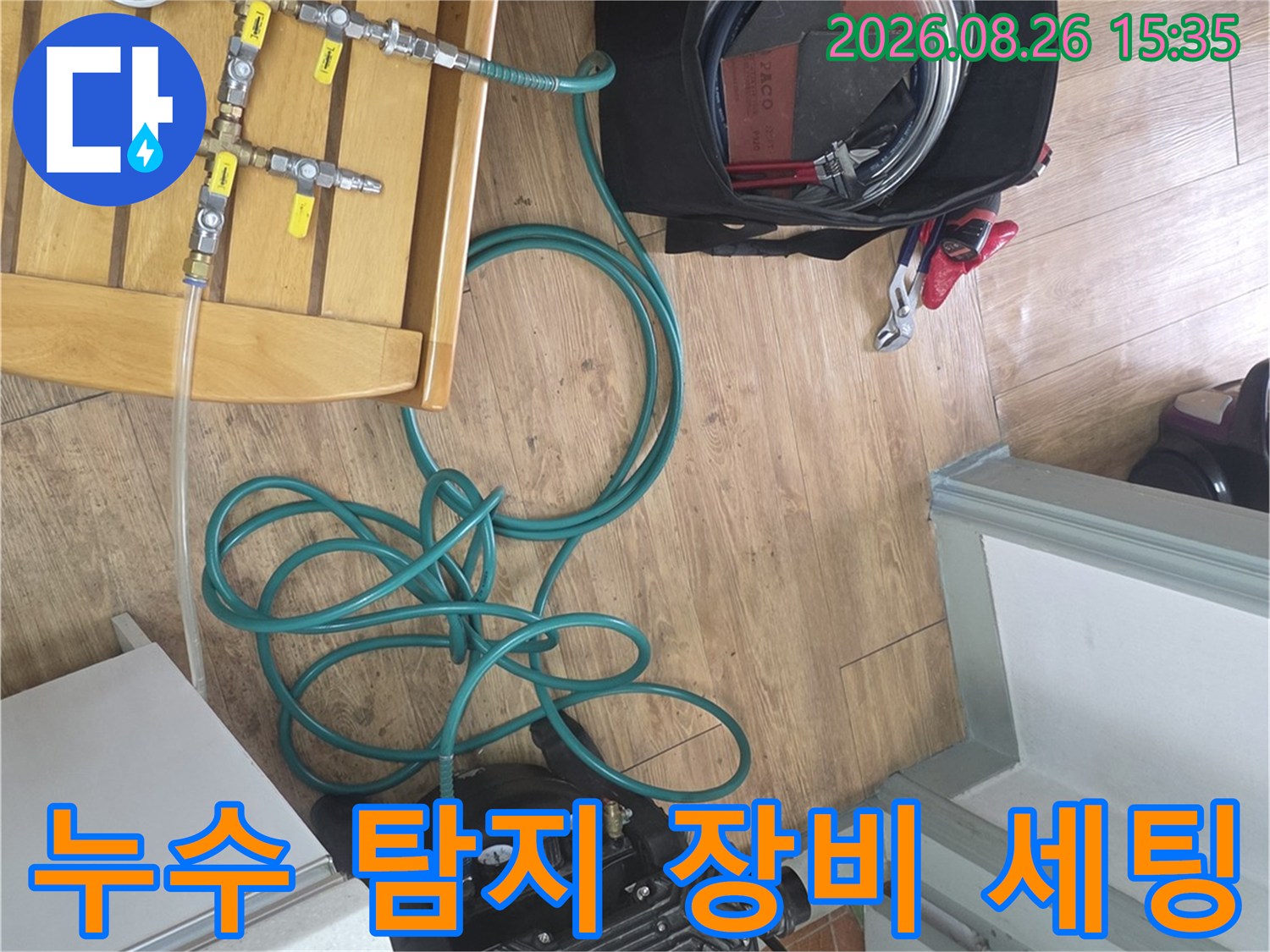 누수 지점을 찾기 위해 압력계와 연결 호스를 준비하고 있는 작업 현장입니다.