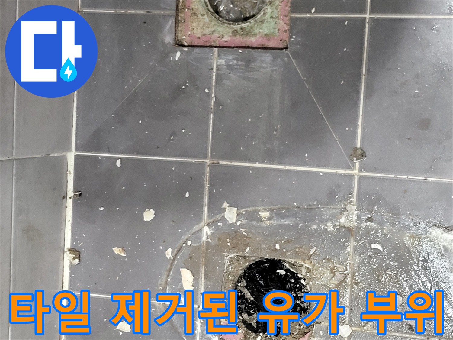 배수구 주변의 젖은 타일과 파손된 바닥면