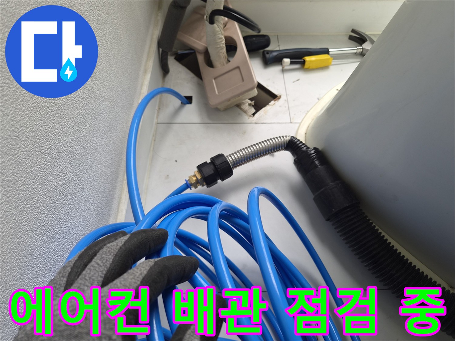 에어기 배관 연결부와 파란색 호스를 점검하는 엔지니어의 모습