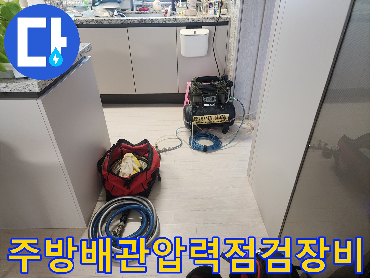 싱크대하부장-바닥에_놓인_공압테스트용_콤프레셔와_배관_연결호스
