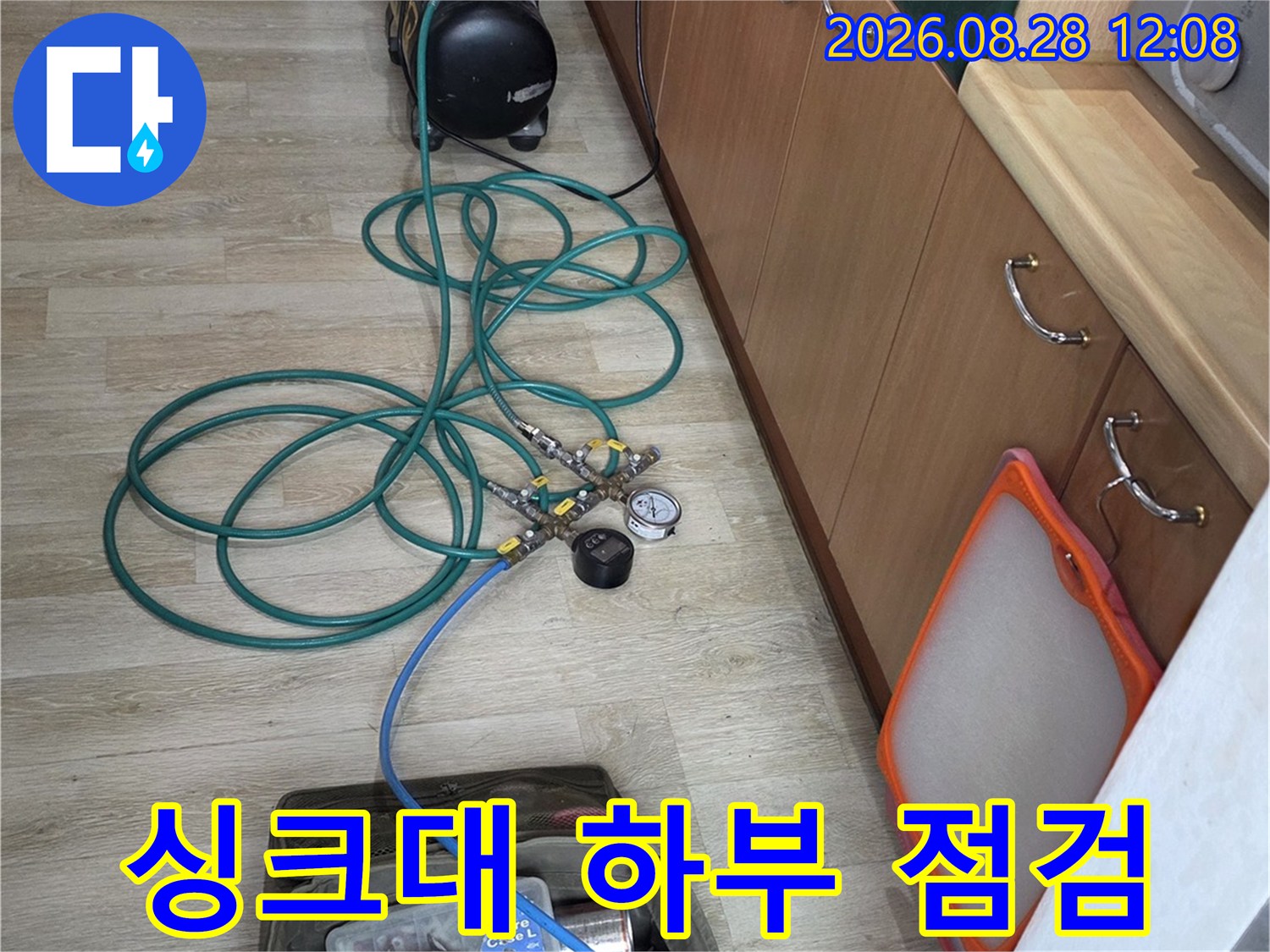싱크대 아래 배관 연결 부위를 정밀하게 검사하는 전문 장비와 작업 모습입니다.