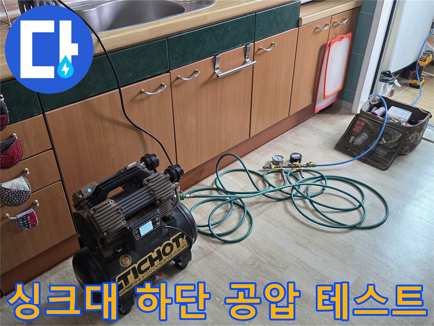 싱크대 하부장 바닥에 놓인 공압 테스트 장비와 연결 호스