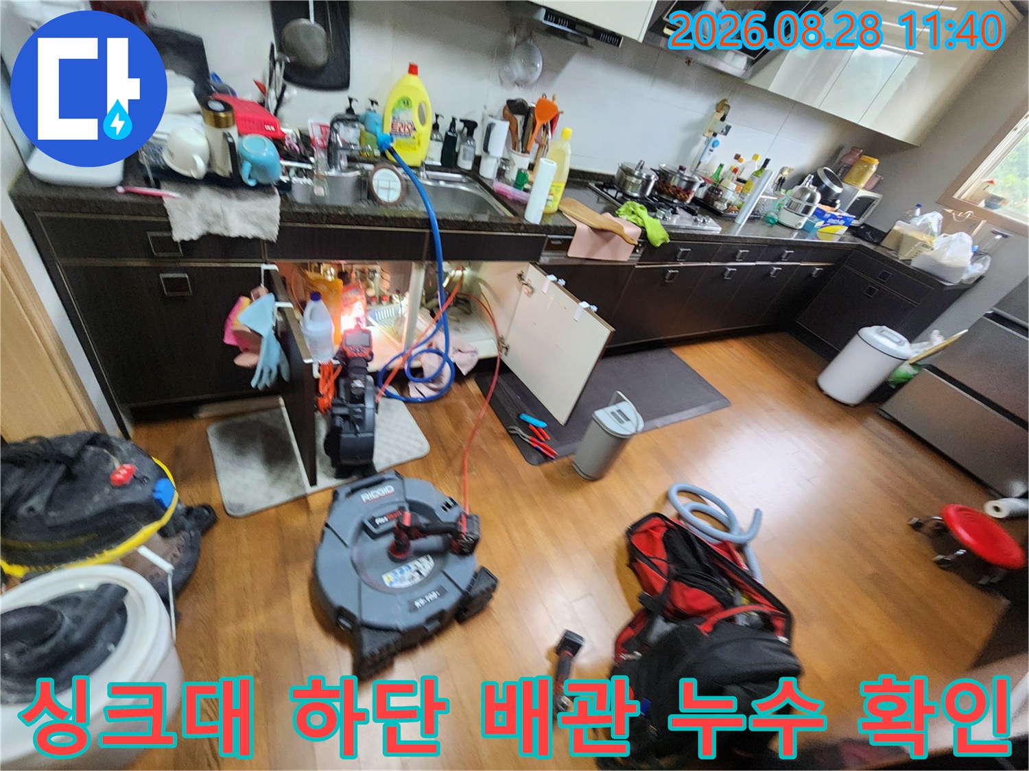 싱크대 밑부분 배관 상태와 점검 장비가 놓여있는 작업 현장
