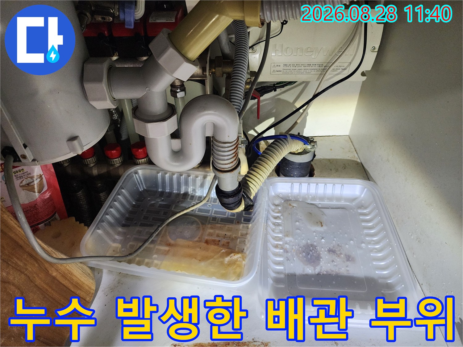 싱크대 하부 배관 연결 부위의 누수 흔적과 물 고임