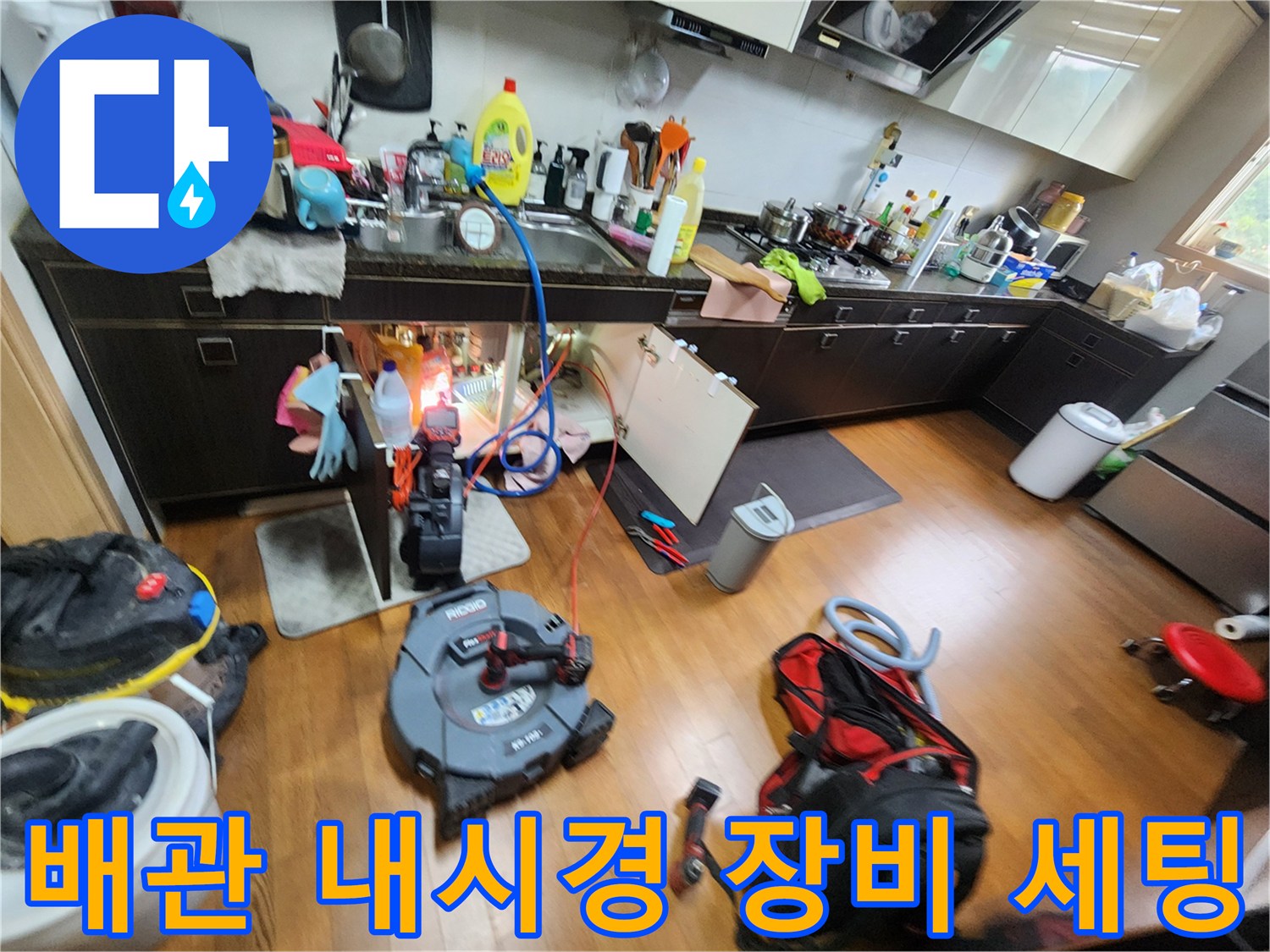싱크대 하부 배관 점검을 위해 설치된 전문 내시경 및 청소 장비