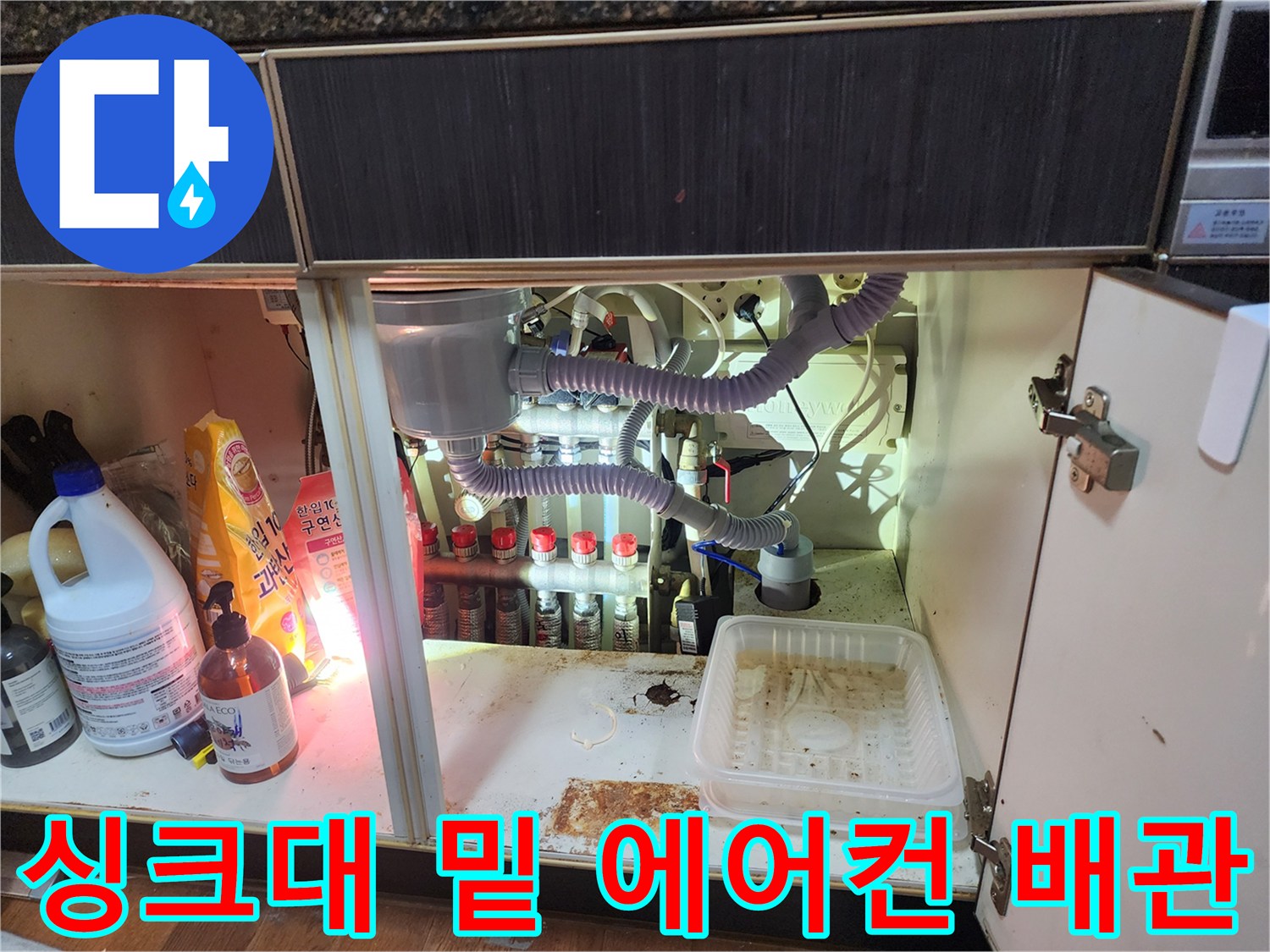 싱크대 하부장에 연결된 에어컨 드레인 호스와 하수구 연결 관로