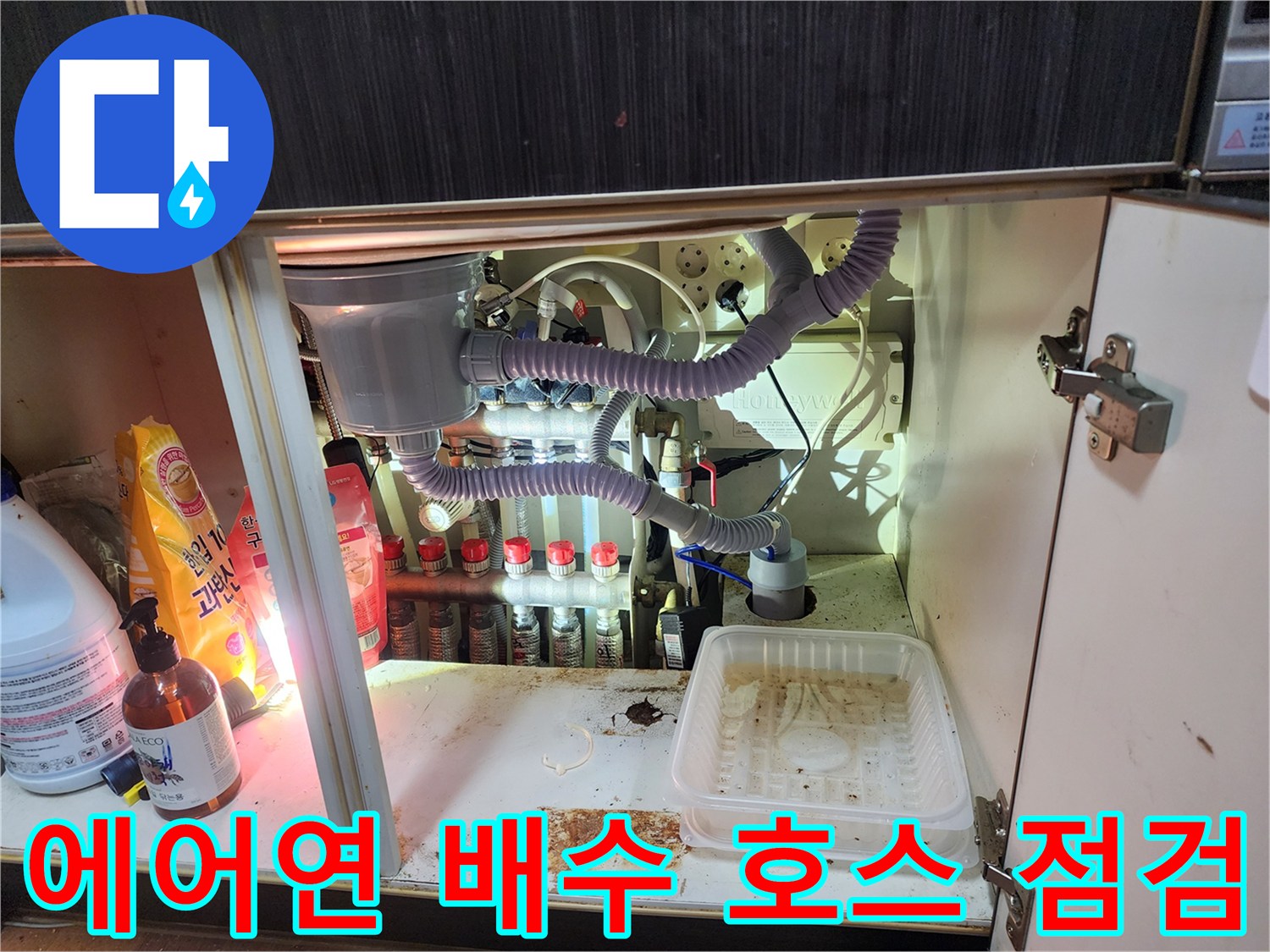 에어컨 응축수 유도 호스와 싱크대 하부 연결 배관의 복합적인 구조