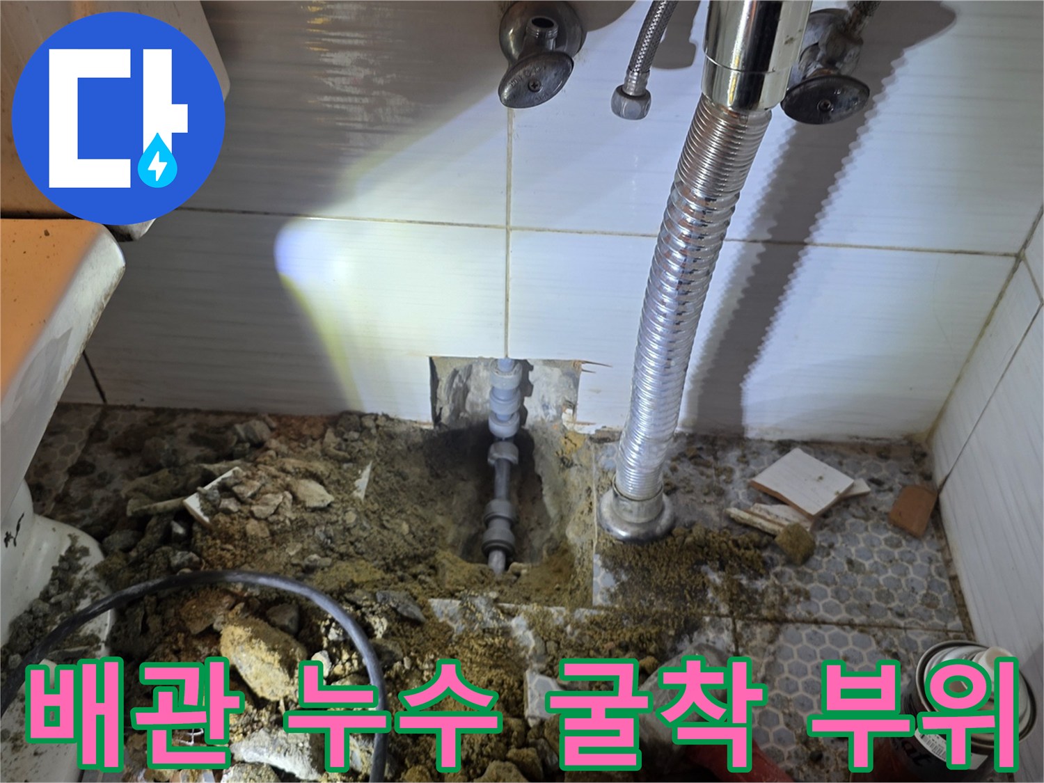 화장실 바닥을 파내어 드러난 노출된 배관과 주변 공구들