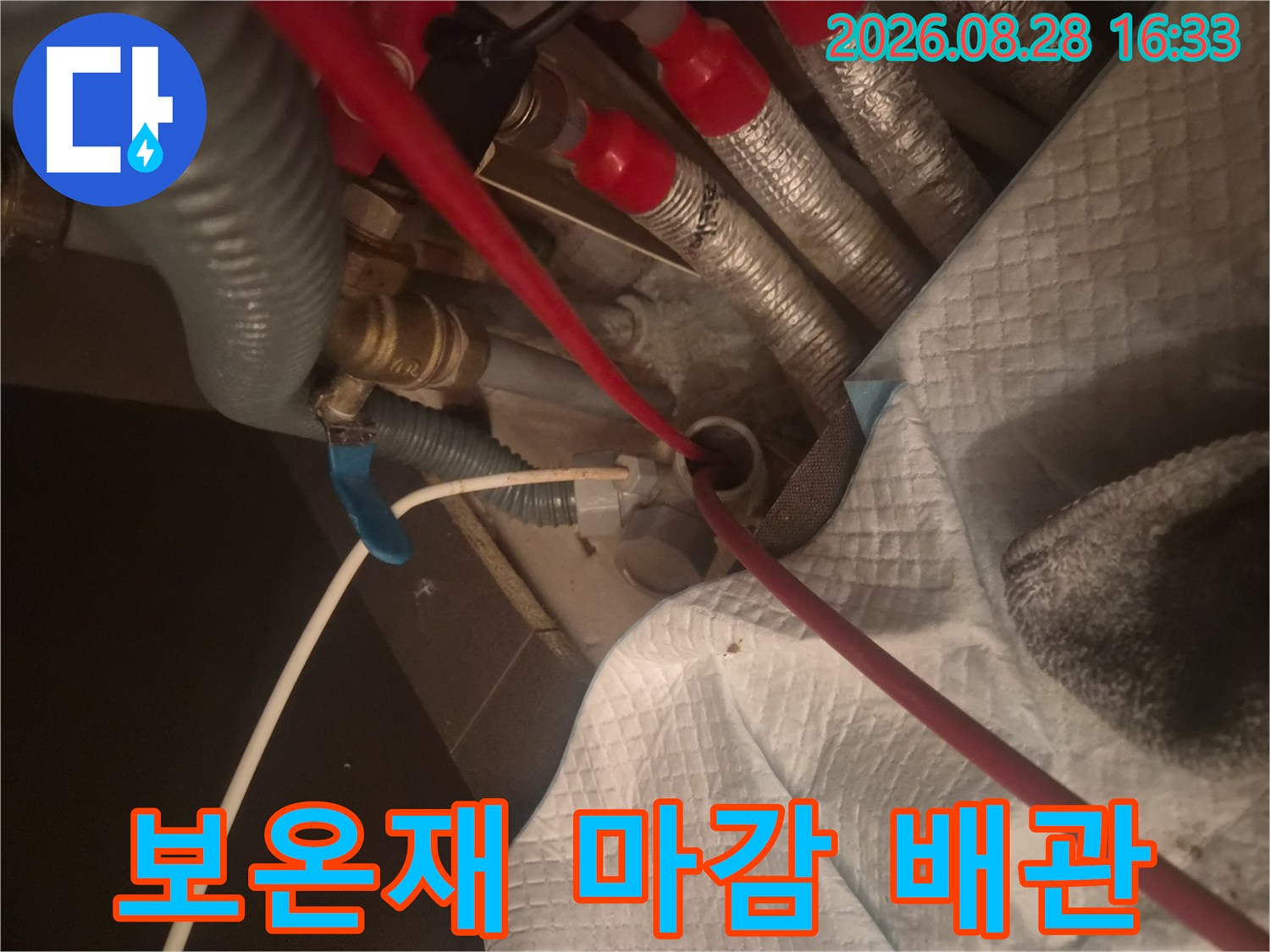 은색 보온재와-붉은 호스가 연결된 싱크대 하단 배관 현장