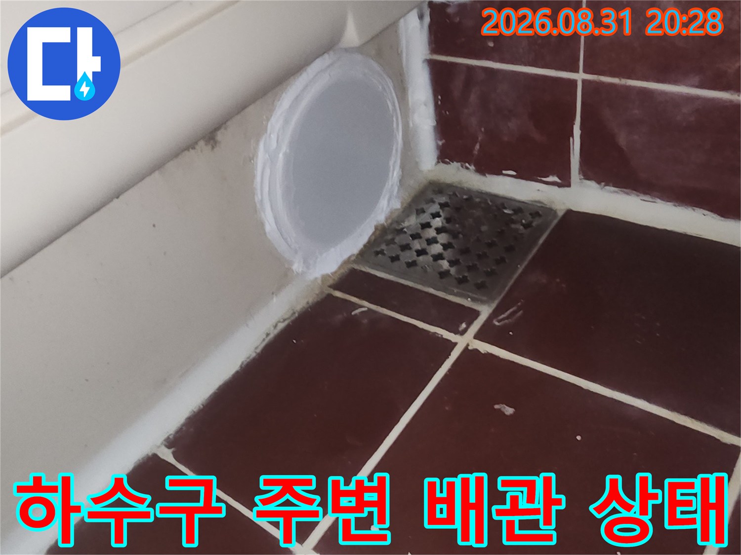 욕실 타일과 하수구 유가 연결 부위를 근접 촬영했습니다.