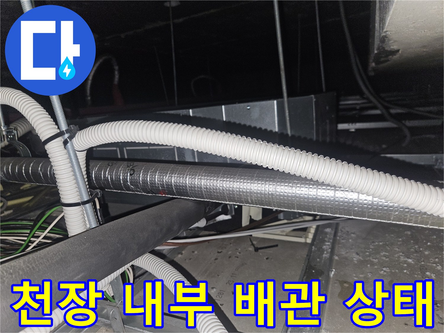 하얀색 주름관과 은박 보온재로 마감된 천장 배관 작업 사진입니다.