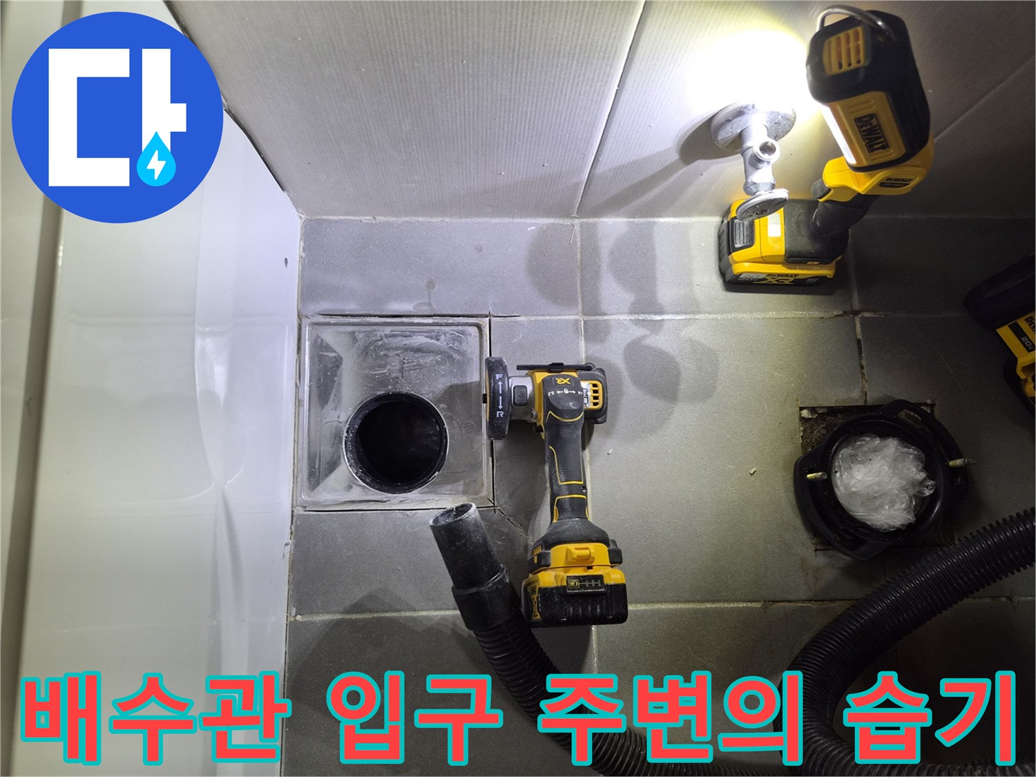 변기 제거 후 드러난 젖은 타일과 하수 배관 부위