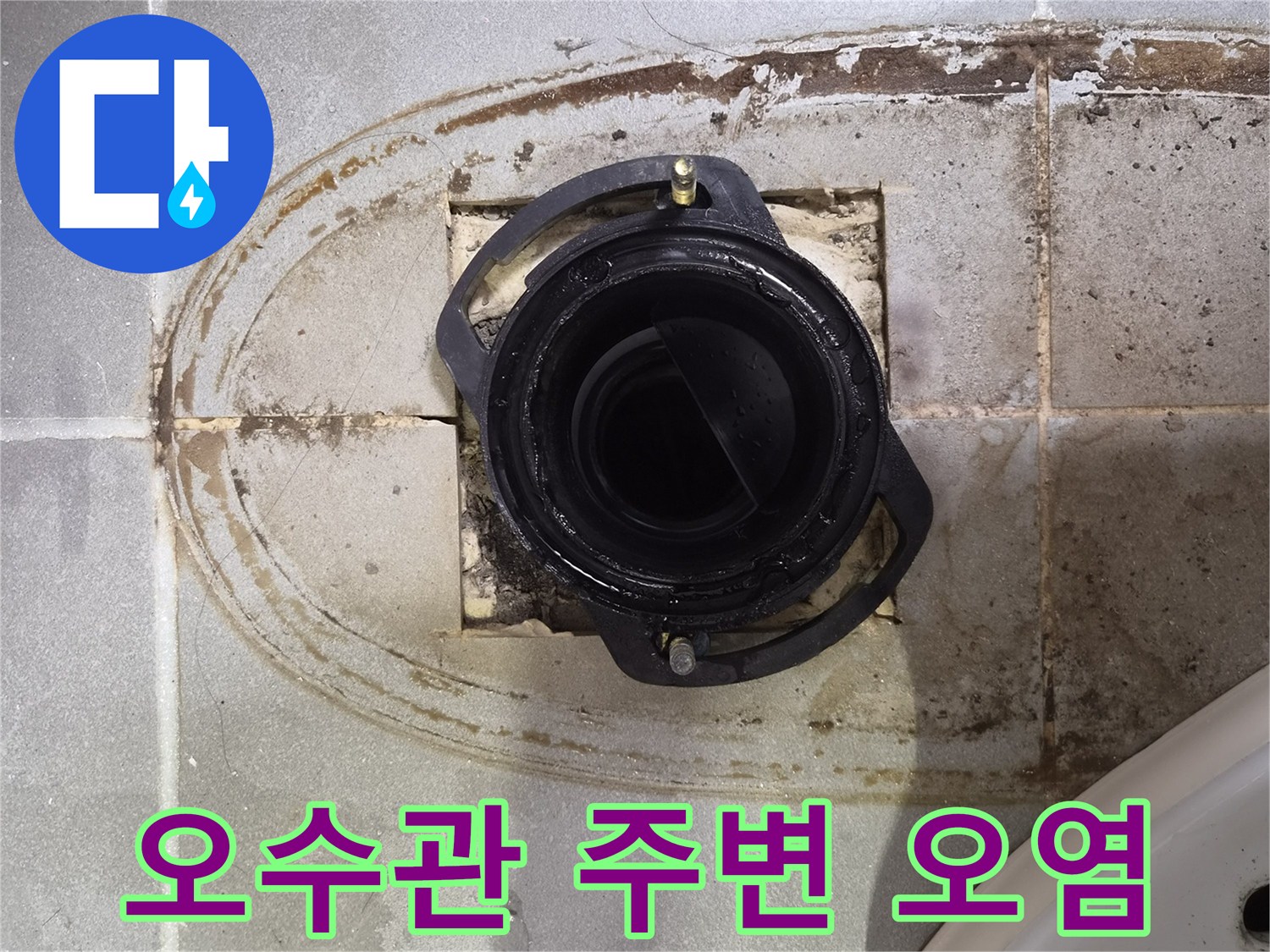 변기 하부 배관 입구의 젖은 타일과 변색된 부위