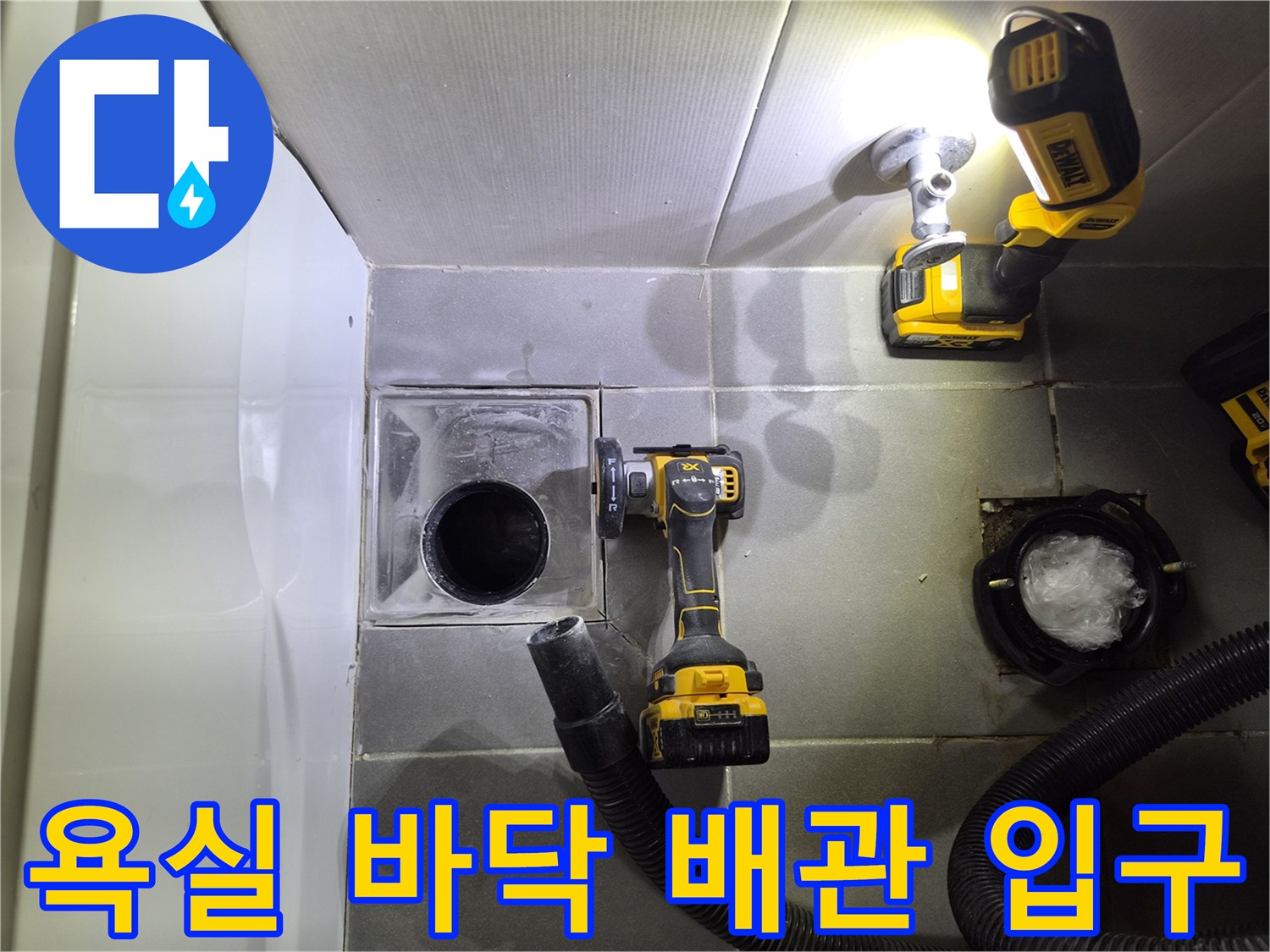 작업용 드릴과 흡입 호스가 놓인 화장실 탈거 작업 부위