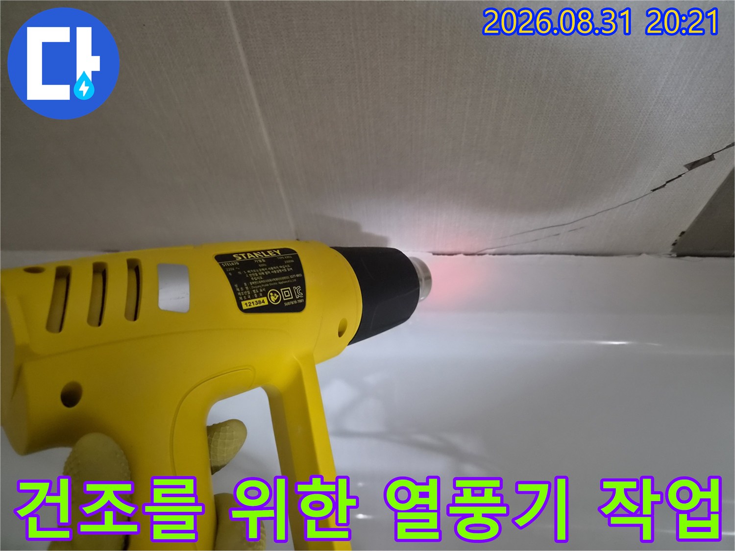 틈새 사이의 물기를-말리기 위해 열풍기를 사용하고 있습니다