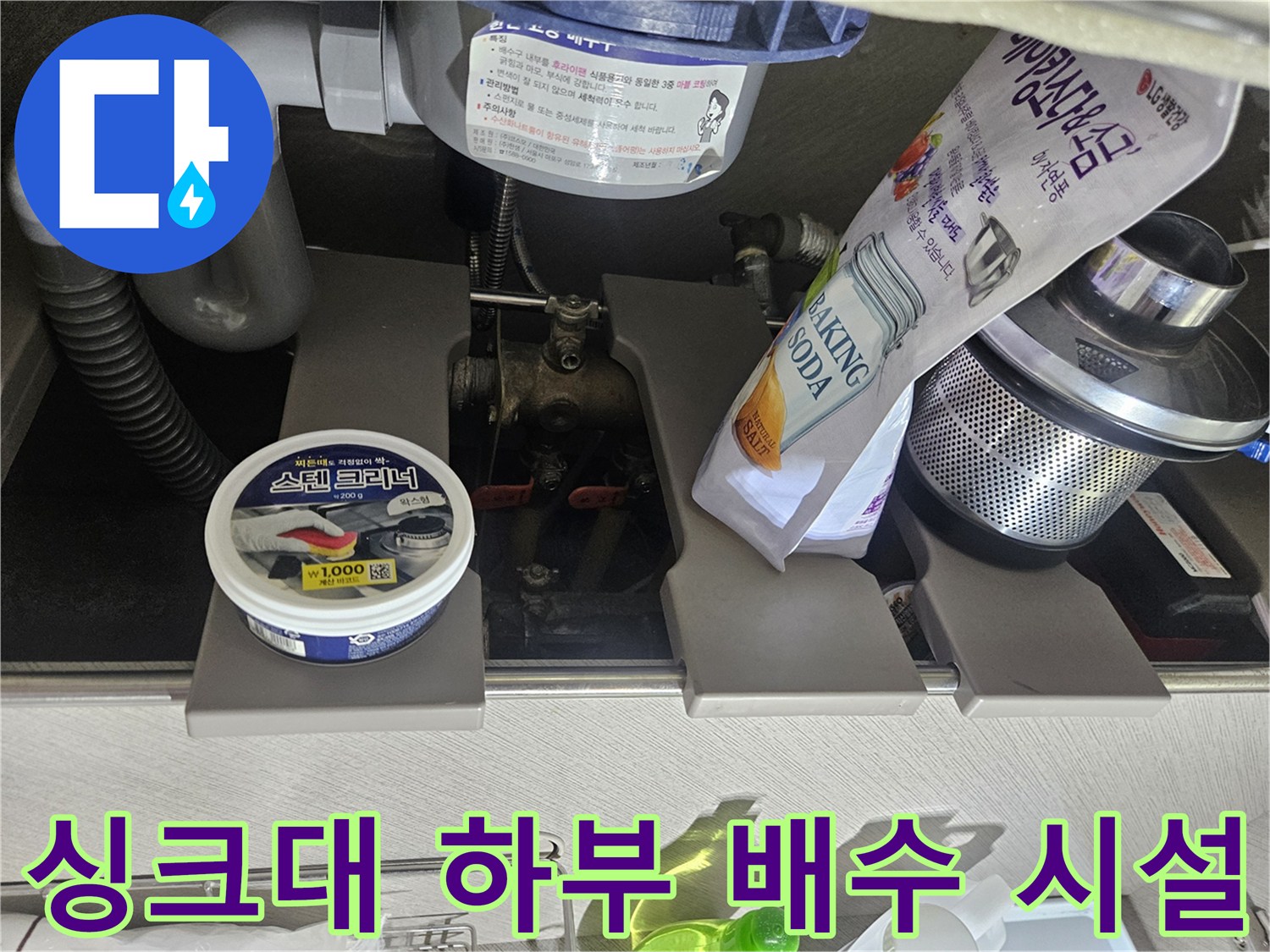 주방 싱크대 하단-연결된 굵은 호스와 분기 배관의 모습