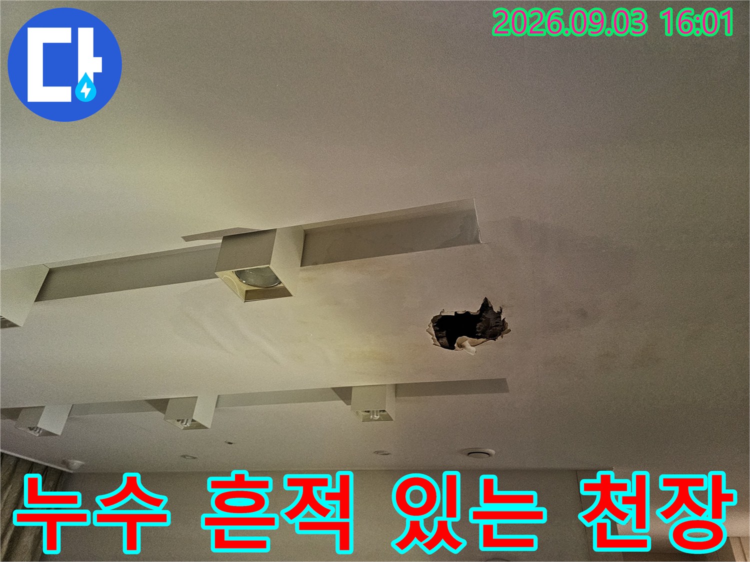 누수로 인해 변색된 천장 마감재와 타공된 부위 사진