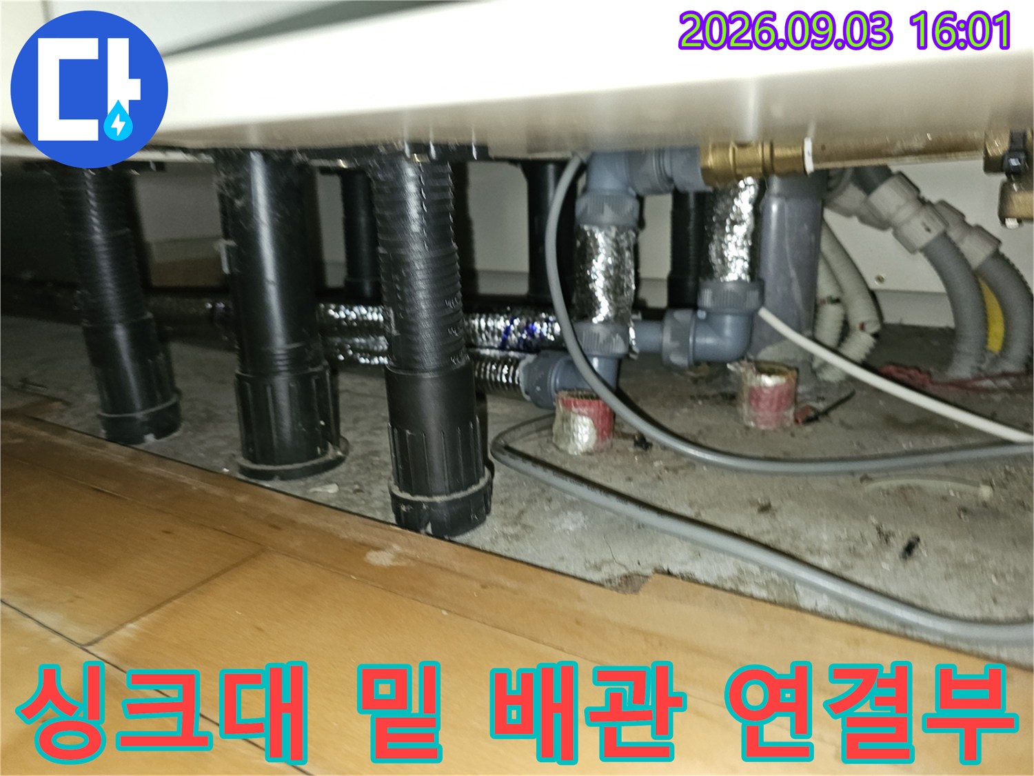 복잡하게 얽힌 싱크대 하단 배관과 전선들의 모습