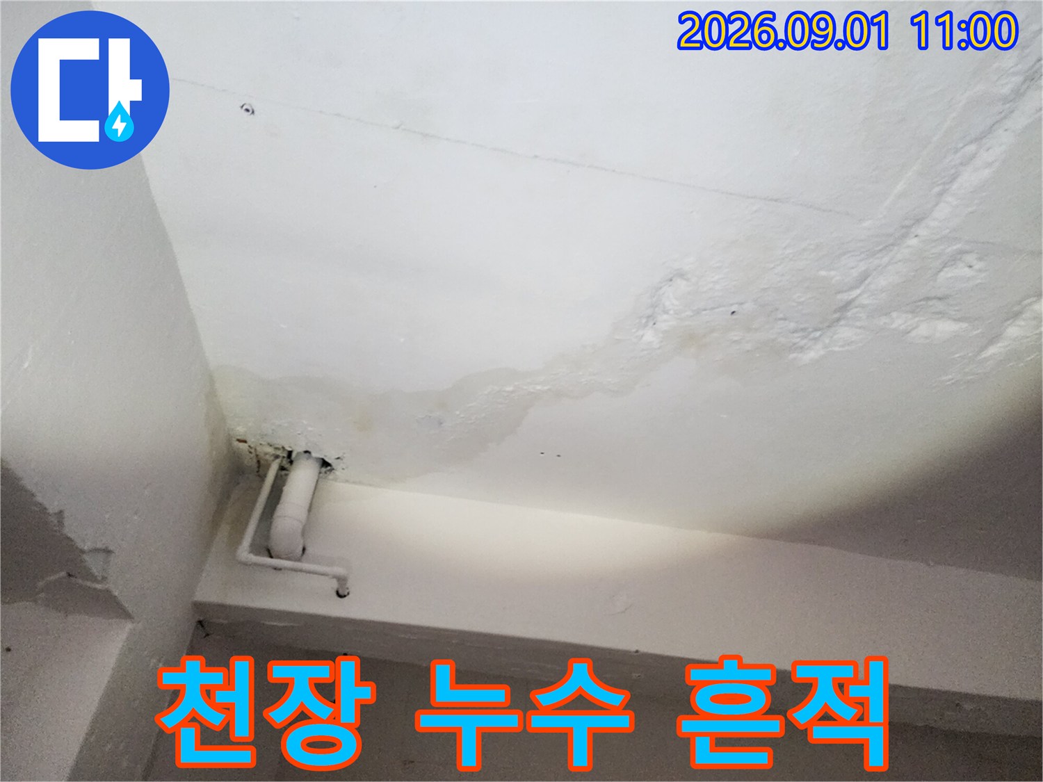 천장 마감재의 변색된 누수 얼룩과 배관 구조물