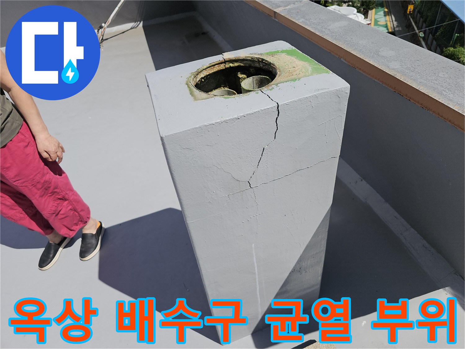 배수구가 설치된 콘크리트 기둥의 갈라진 부분을 보여줍니다.