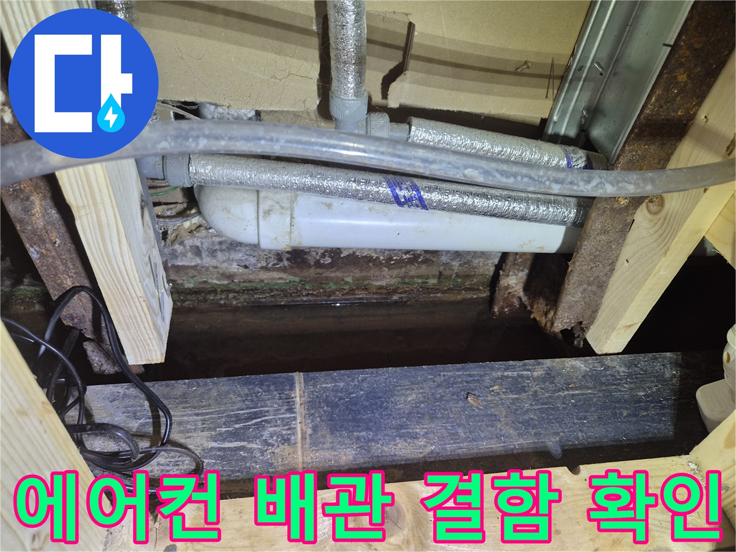 보온재로 감싸진 에어컨 드레인 배관과 젖은 목재 부위