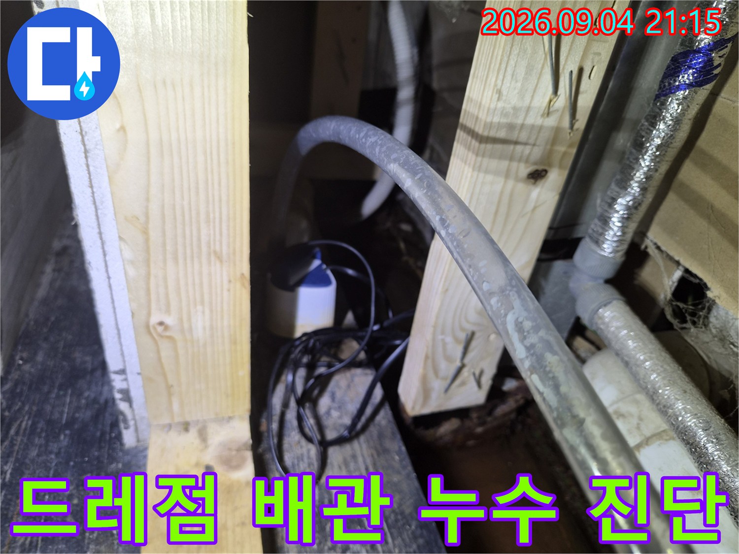 상가 내부 천장의 목재 지지대와 에어컨 드레인 호스 연결 부위
