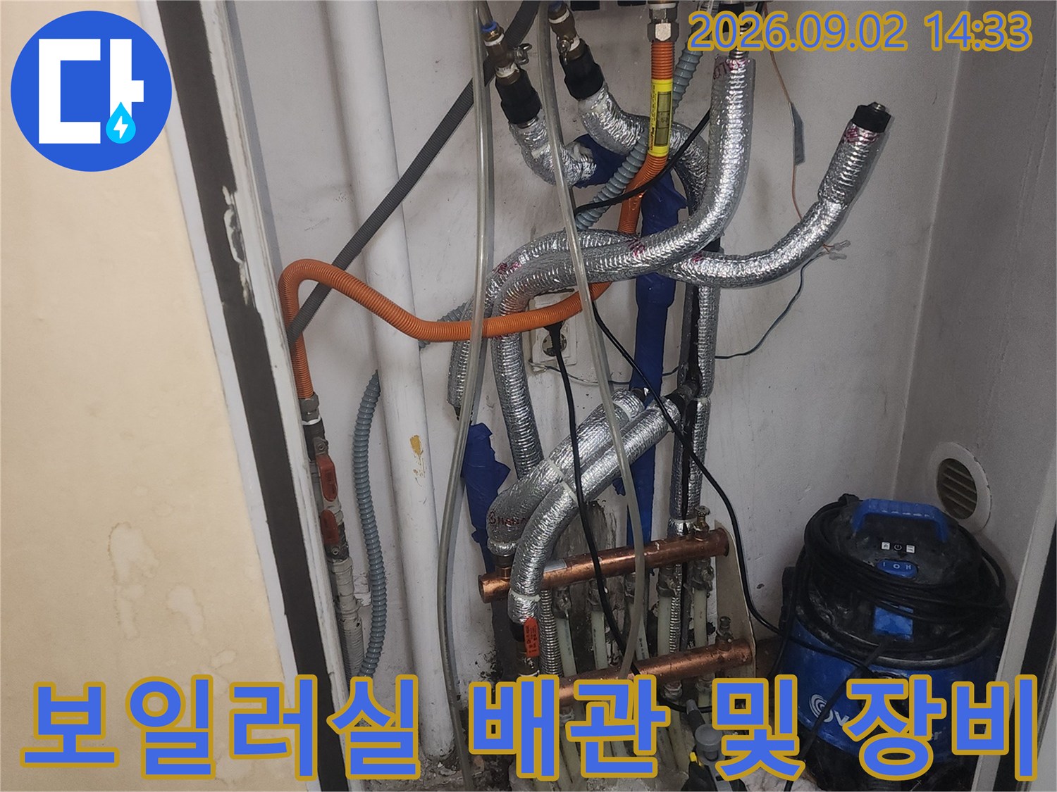 보일러와 연결된 은박 보온재 배관과 현장 작업 도구들