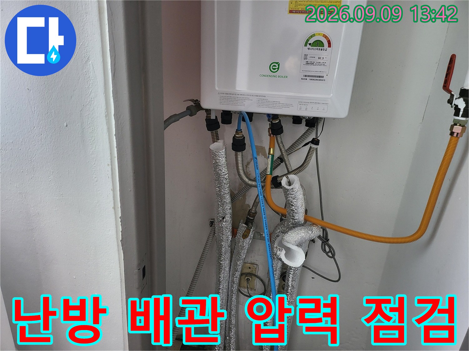 보일러실 배관 연결 부위에 장비를 설치하여 배관 내부의 누수 여부를 진단하는 장면입니다.
