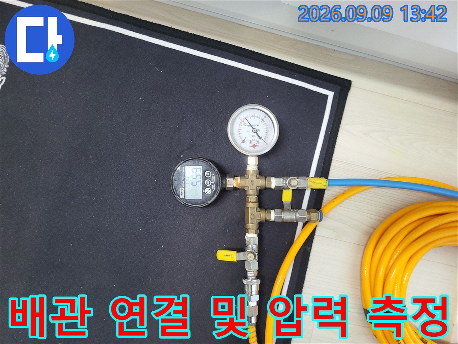 황동 밸브와 호스가 연결된 보일러 배관 점검 장치
