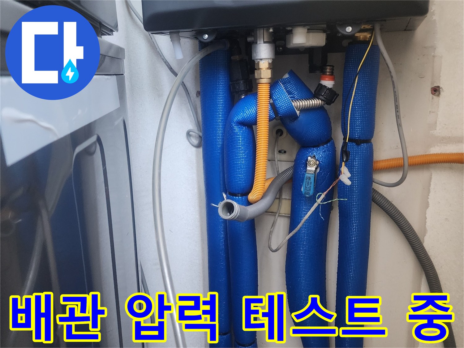 파란색 단열재로 덮인 배관에 연결된 공압 진단 장비의 모습