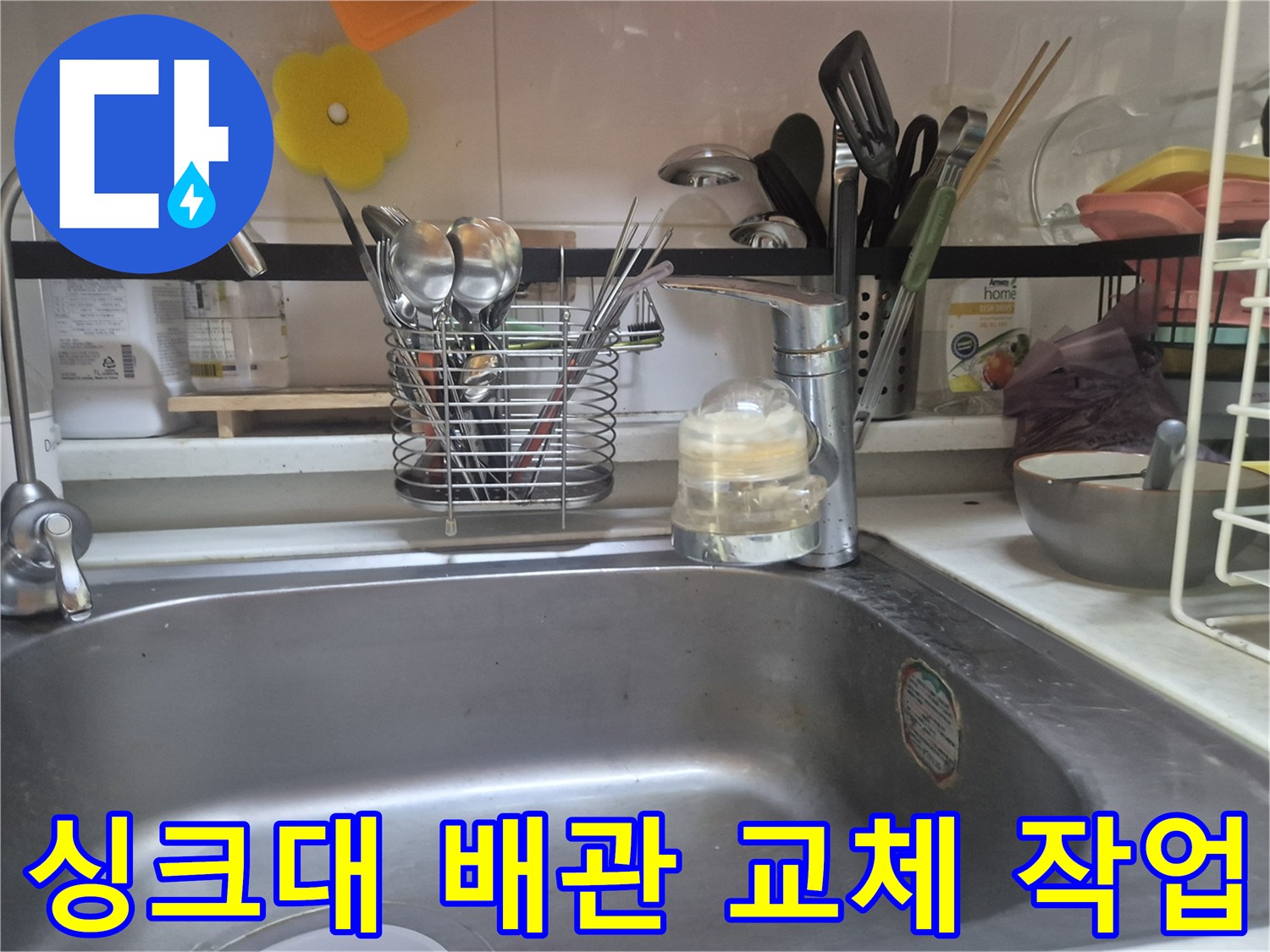싱크대 수전과 주변 주방 용품이 놓인 모습