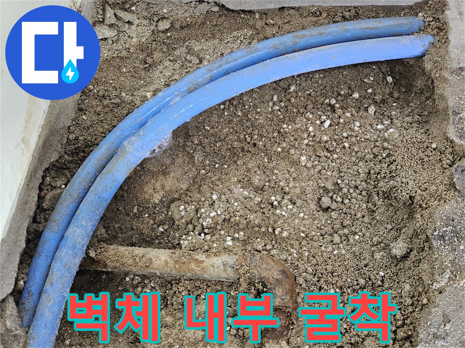 벽을 깨서 드러난 파란색 수도 배관과 노후 금속관