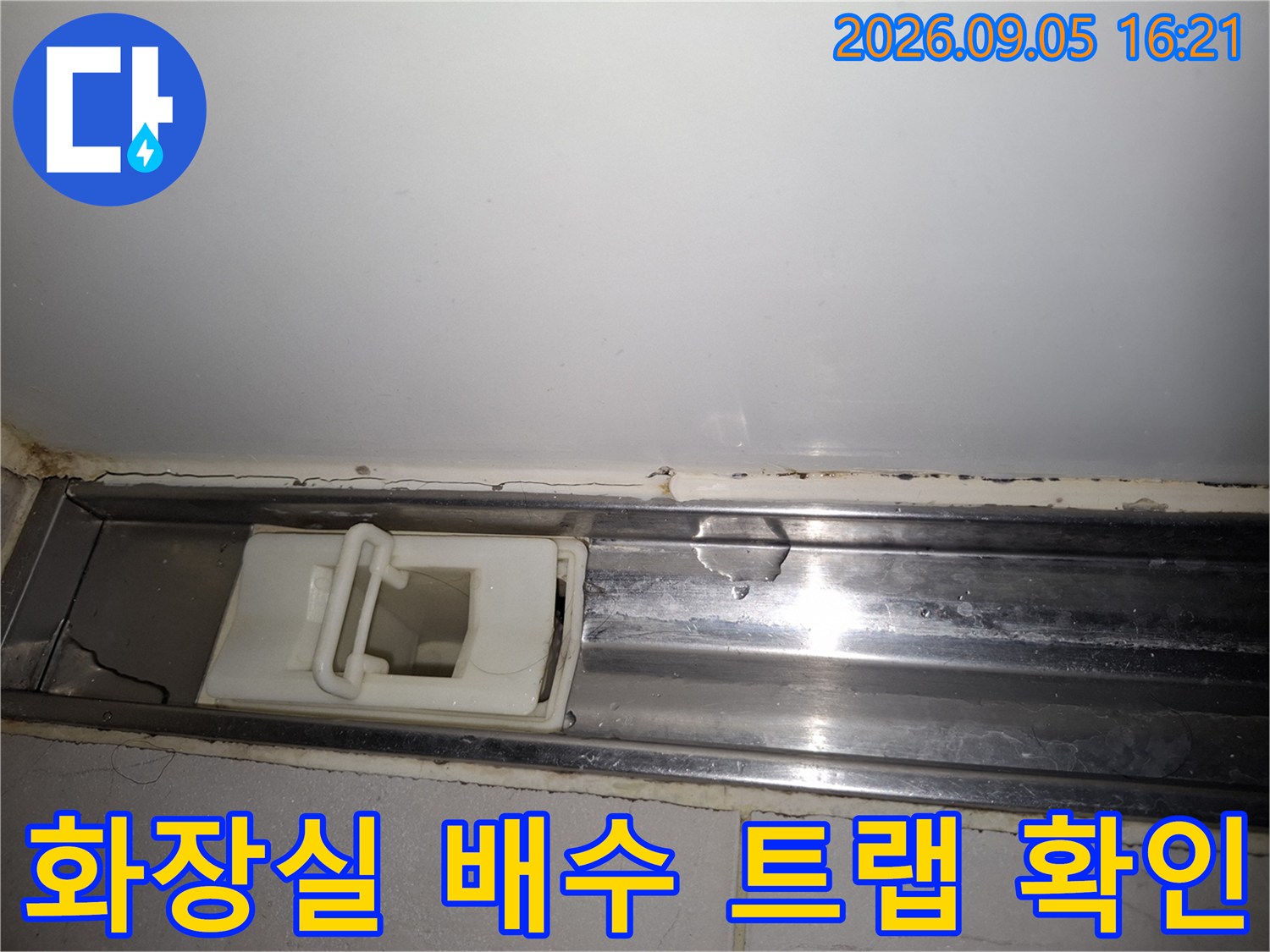 상도동 현장의 욕실 배수구 내부 부속과 주변 타일 상태를 보여줍니다.