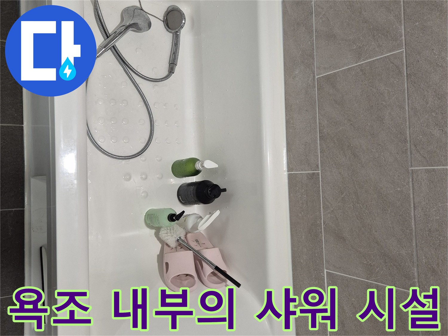 화장실 욕조에 놓인 세면 용품과 샤워기 헤드