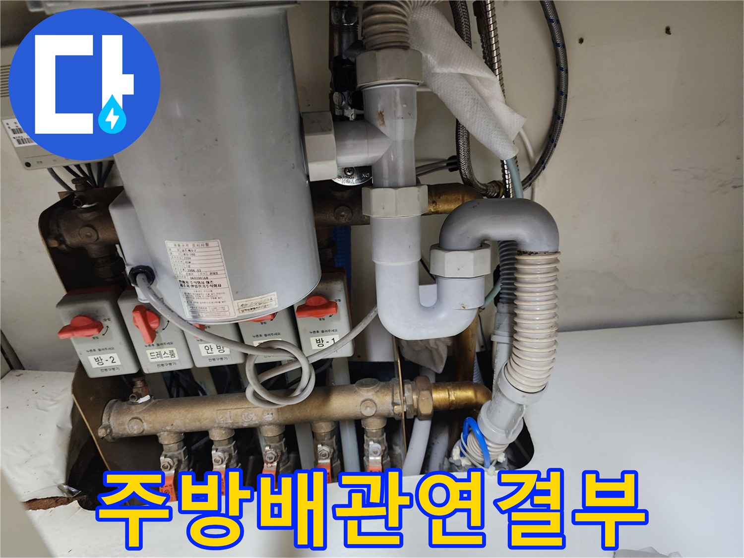 싱크대 아래쪽 여러 갈래의 수도 밸브와 배관 구조