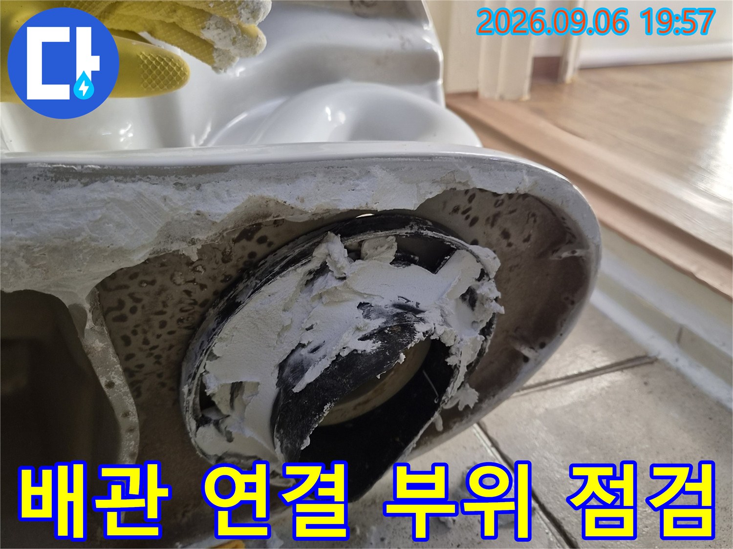 세면대 배수구가 탈거된 자리에 남은 배관 부속과 젖어있는 타일의 모습입니다.