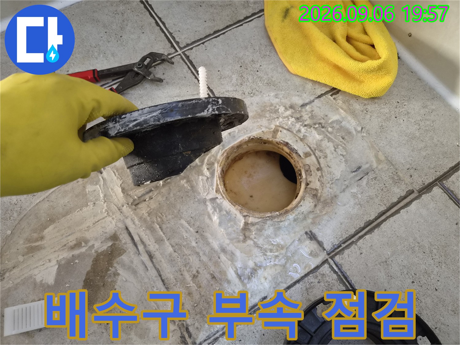 탈거된 배수구 트랩과-노출된 오수관 주변의 작업 모습입니다.