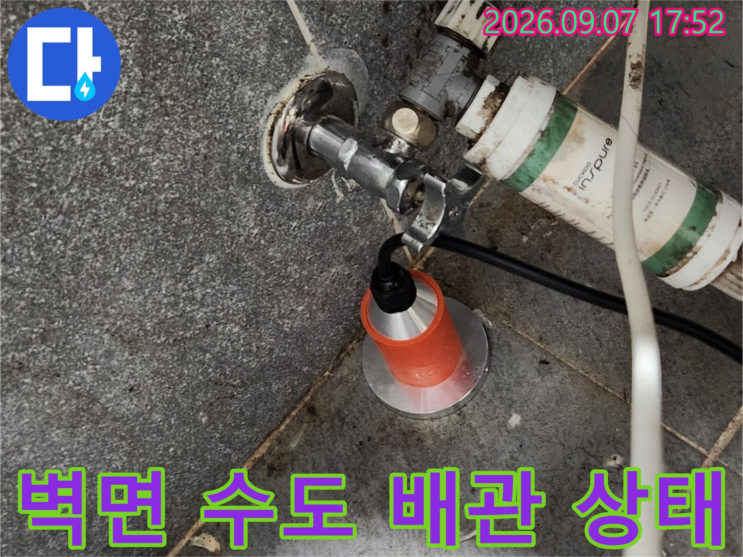 화장실 타일 벽면에 설치된 수도 수전과 연결 부위 근접 촬영