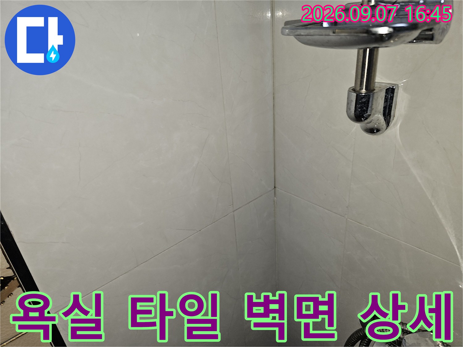 대리석 패턴의 욕실 타일과 샤워기 수전 부위
