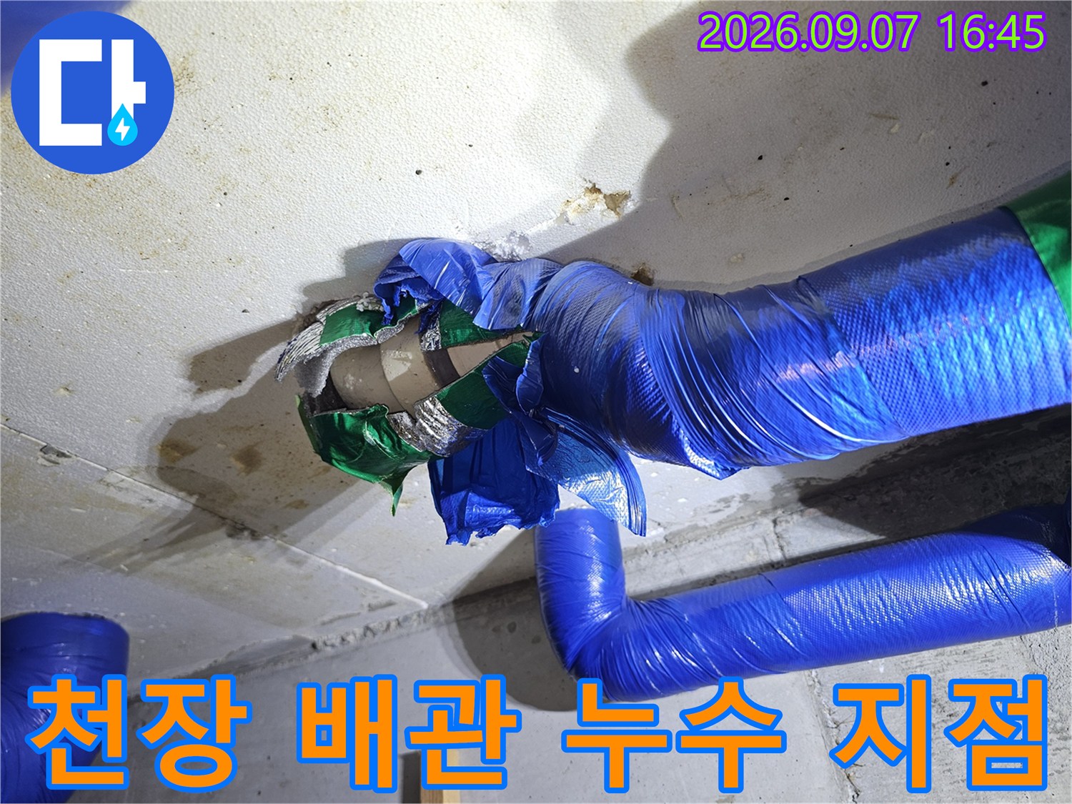 파란색 보온재로 감싸진 배관과 젖어 있는 천장 콘크리트