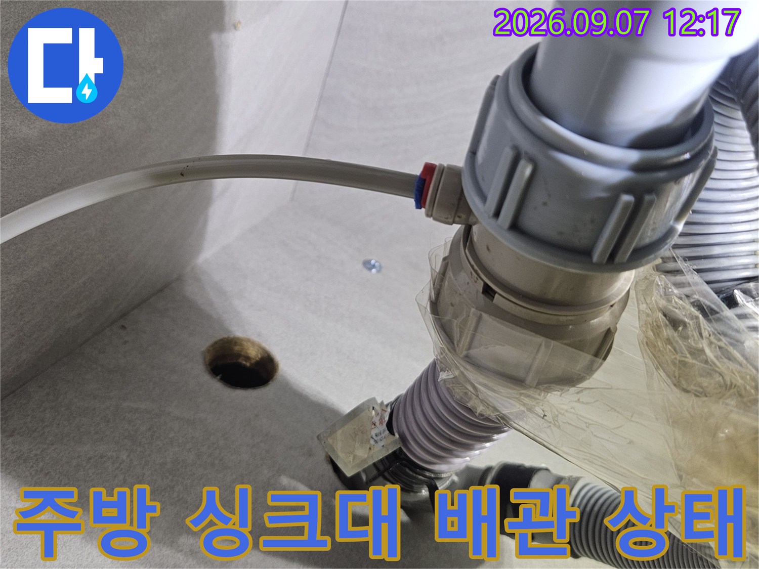 불완전하게 연결된 정수기 호스와 싱크대 하부 배관