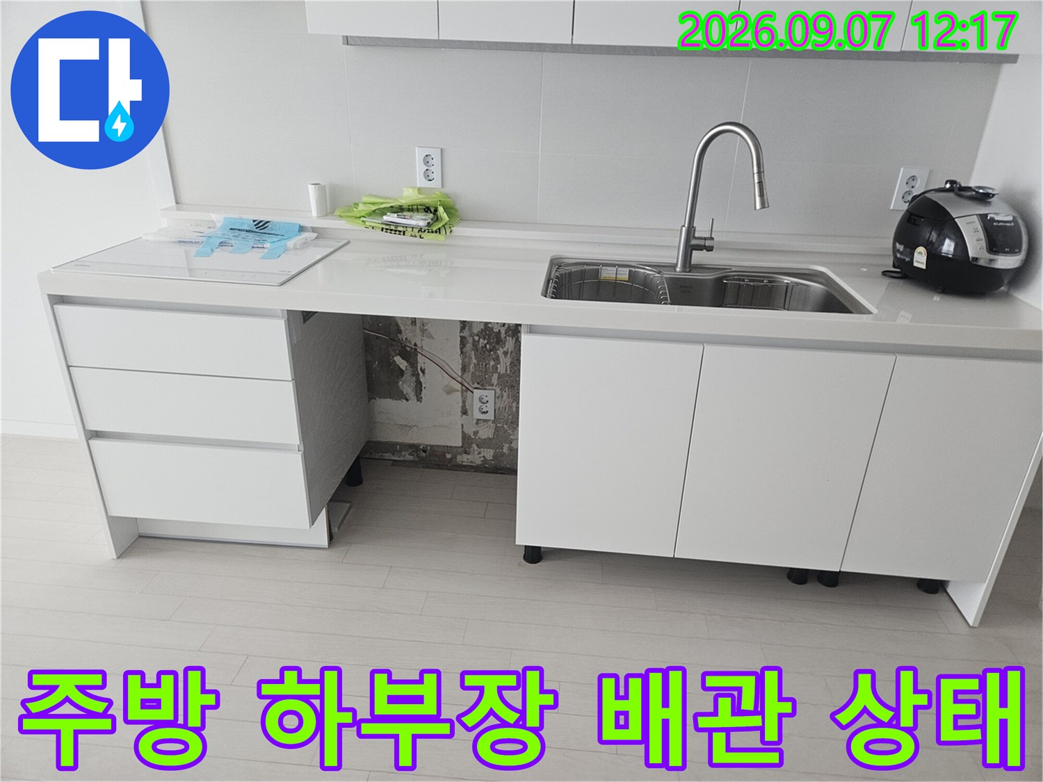 싱크대 밑 정수기 호스 연결 부위의 누수 지점을 파악하는 사진입니다.