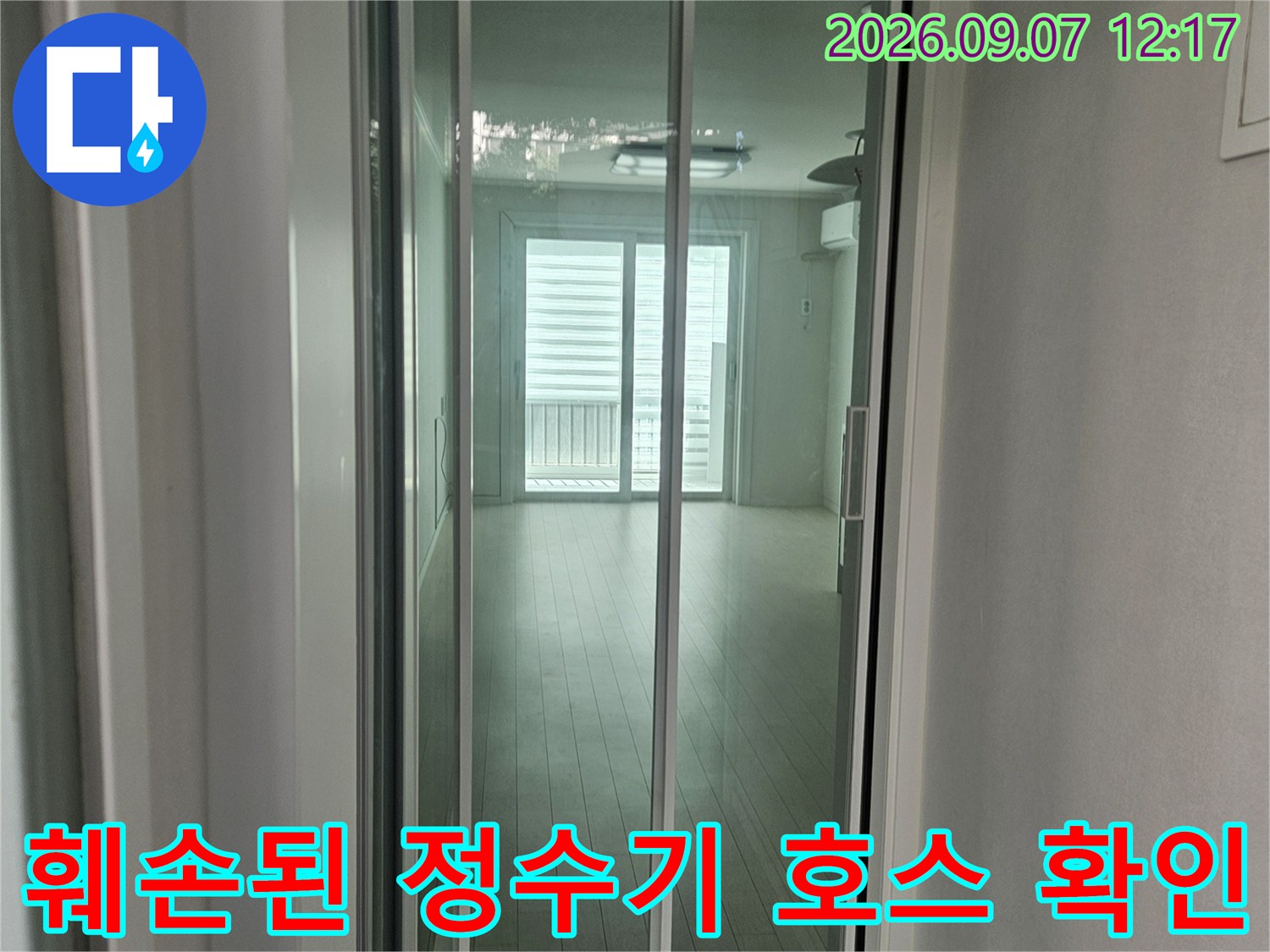 싱크대 하부장 내부의 훼손된 정수기 호스 연결 부위를 근접 촬영한 사진입니다.