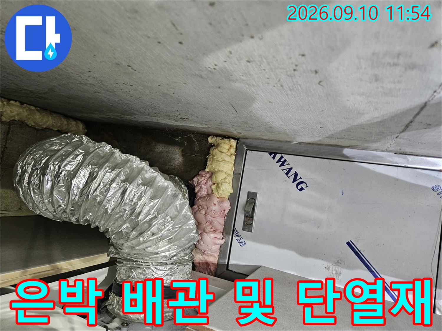 천장 내부-은색 은박 자재로 감싸진 굴곡진 배관의 모습입니다.